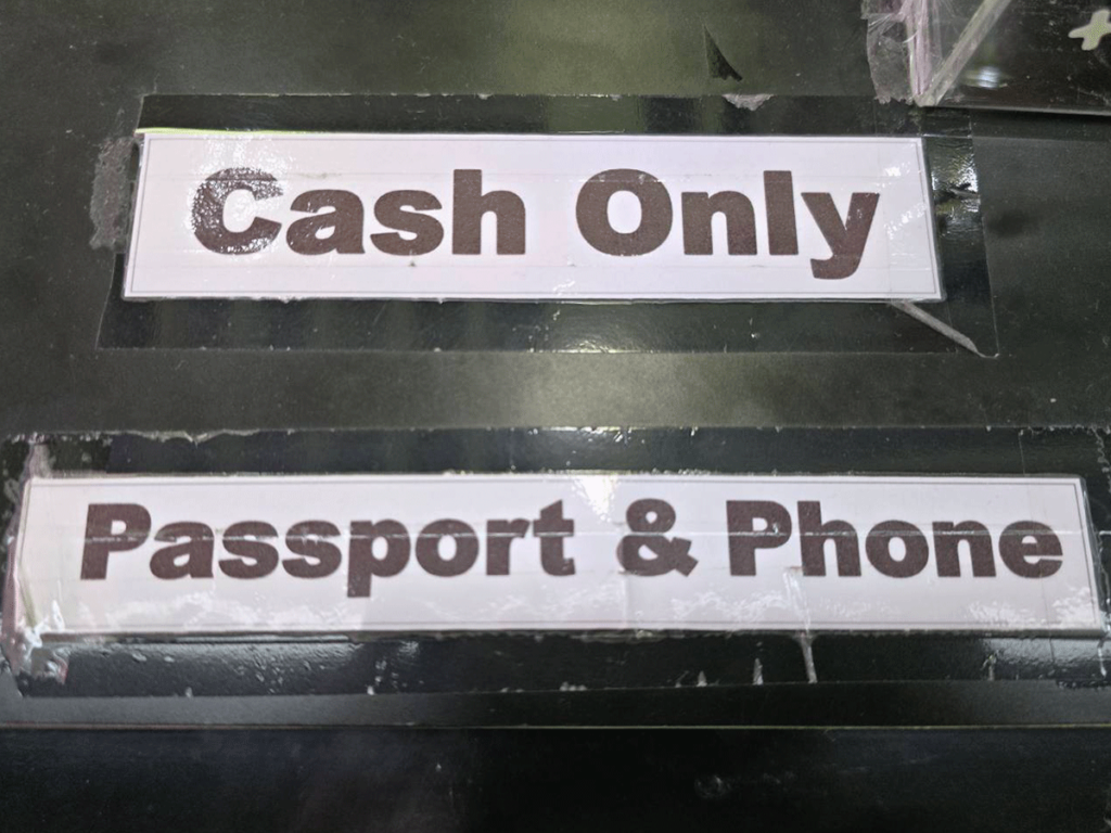 Best Bangkok Tourist sim card and esim – Signage at the airport phone booth saying "cash only" and "Passport & Phone"