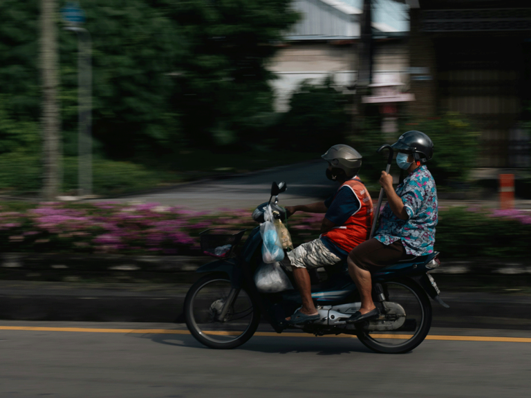 How to ride a motorbike safely in Bangkok – a motorbike rider with a passenger on a street